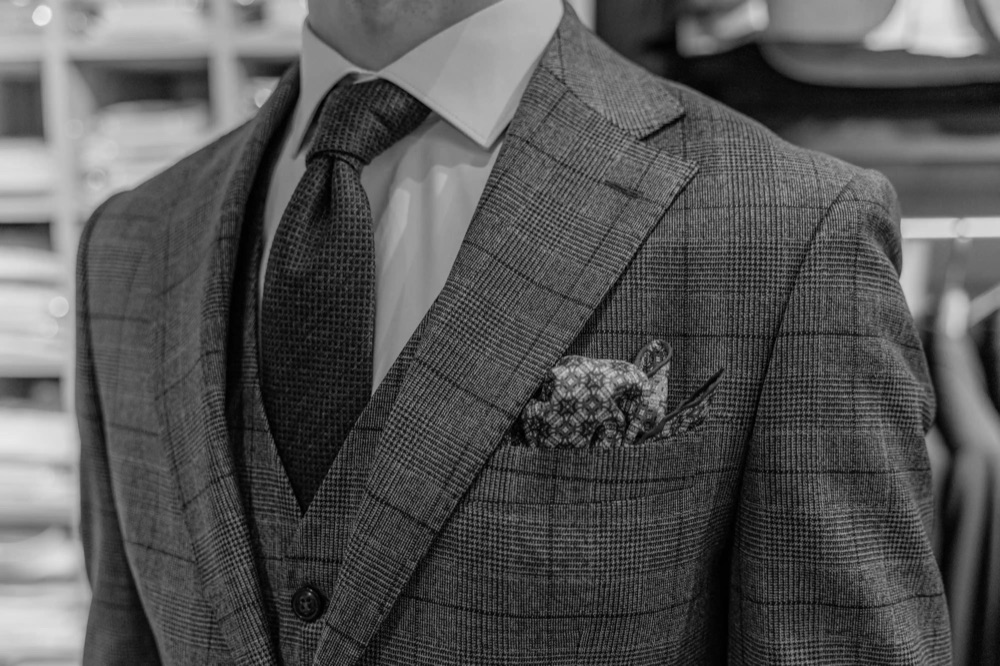 A close-up of a checked sport coat with a tie and pocket square
